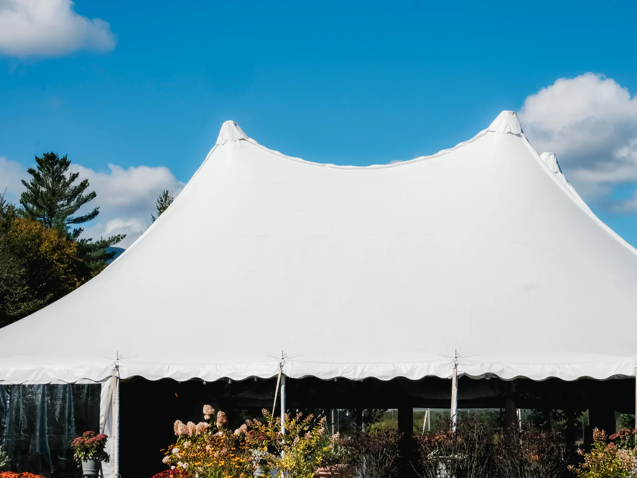 White custom event tent with a tensioned fabric roof beneath a blue sky